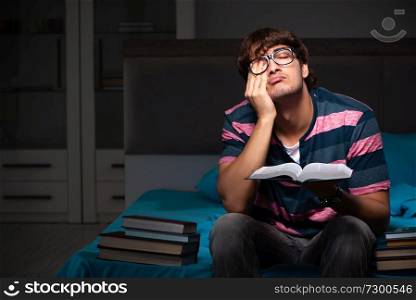 Young handsome student preparing for exams at night