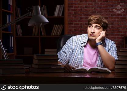 Young handsome student preparing for exams at night 