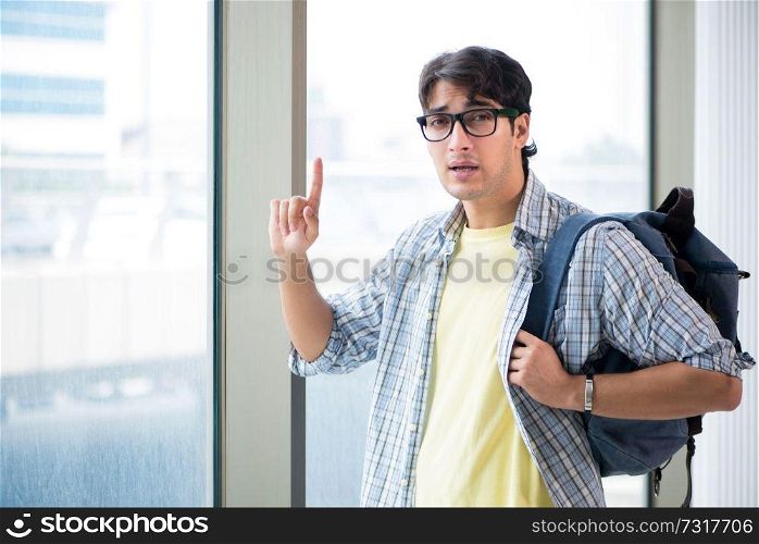 Young handsome student standing at the window 