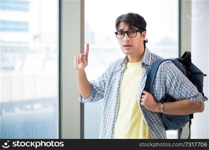 Young handsome student standing at the window 