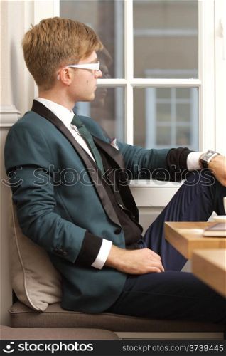 Young handsome stylish man fashion model relaxing thinking and waiting in cafe /restaurant