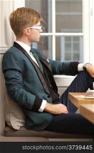 Young handsome stylish man fashion model relaxing thinking and waiting in cafe /restaurant