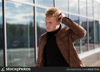 Young handsome stylish man in brown jacket in autumn time outdoor in casual style. Young handsome stylish man in brown jacket in autumn time outdoor in casual style.