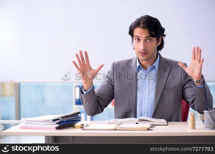 Young handsome teacher in front of whiteboard 