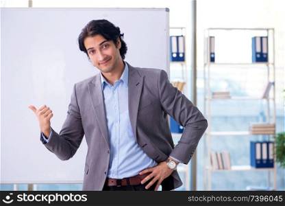 Young handsome teacher in front of whiteboard 