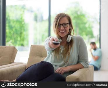 young handsome woman enjoying free time watching television in her luxury home villa