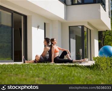 young handsome woman with personal trainer doing morning yoga exercises in front of her luxury home villa