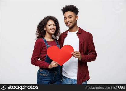Young happy African American couple in love holding red paper heart. Young happy African American couple in love holding red paper heart.