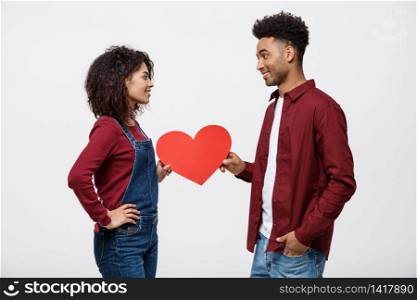 Young happy african american couple in love holding red paper heart. Young happy african american couple in love holding red paper heart.