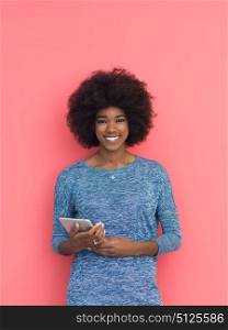 Young Happy African American Woman Using Digital Tablet Isolated on a pink background