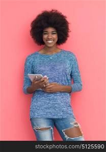 Young Happy African American Woman Using Digital Tablet Isolated on a pink background