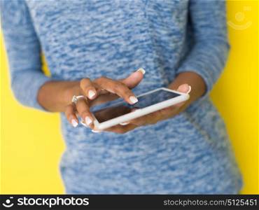 Young Happy African American Woman Using Digital Tablet Isolated on a yellow background