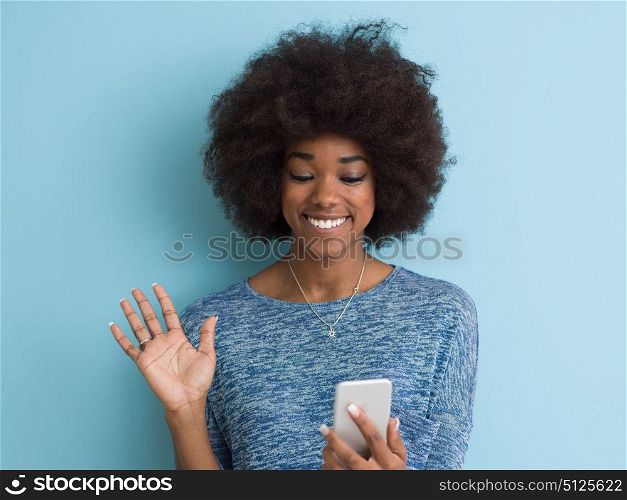 Young Happy African American Woman Using mobile phone Isolated on a blue background
