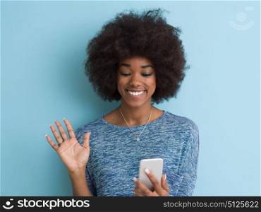 Young Happy African American Woman Using mobile phone Isolated on a blue background