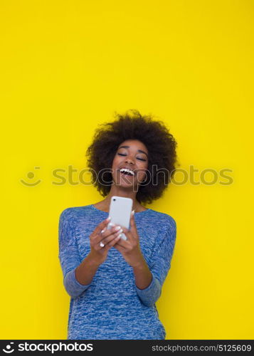 Young Happy African American Woman Using mobile phone Isolated on a yellow background