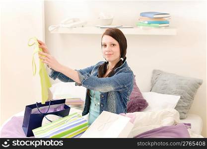 Young happy attractive girl unpack shopping bags in student appartment