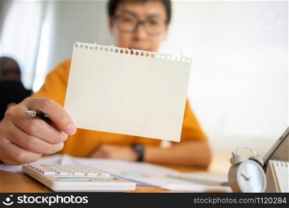 Young happy Business man hand holding empty paper with copy space in front of him Space. Mock up copy space.