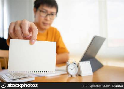 Young happy Business man hand holding empty paper with copy space in front of him Space. Mock up copy space.