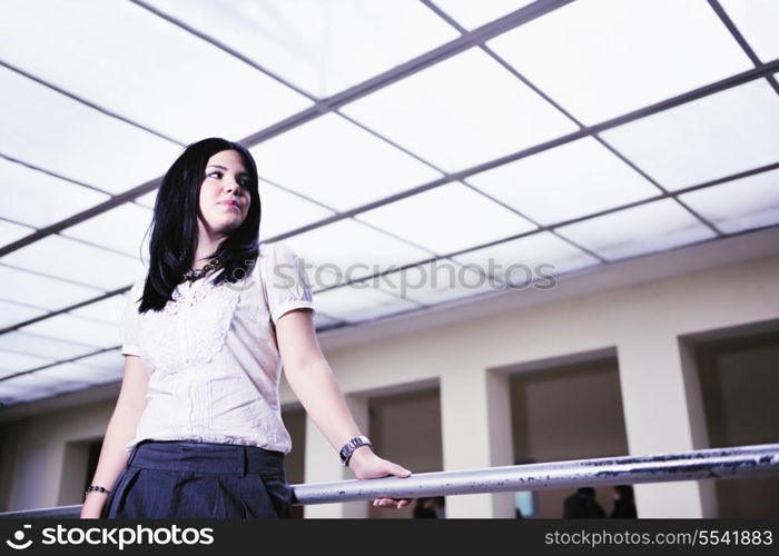 young happy business woman or student posing in fashionable clothes indoor in bright building