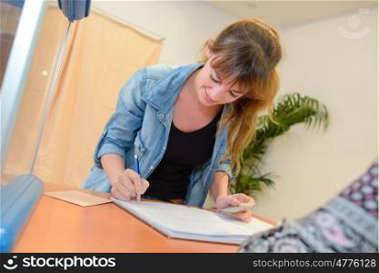 young happy businesswoman writing notes in office