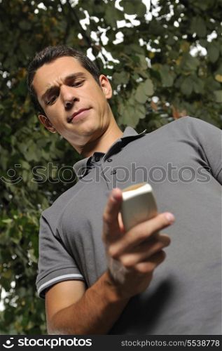 young happy casual man talking on cellphone and writing sms message