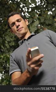 young happy casual man talking on cellphone and writing sms message