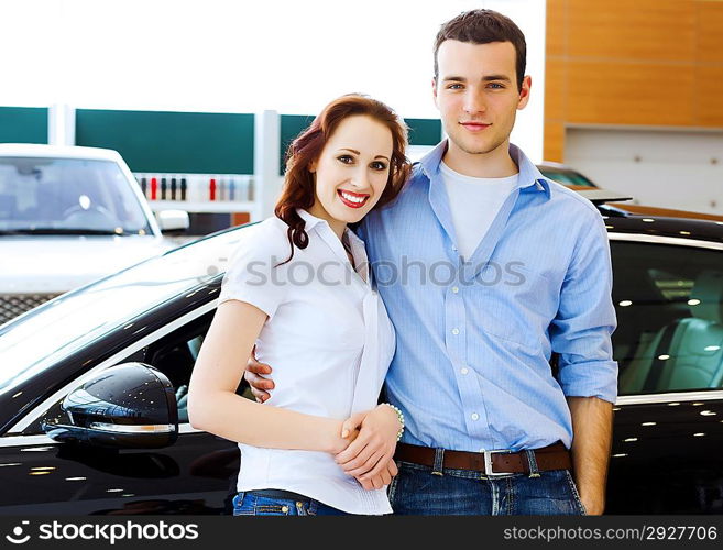 Young happy couple at car salon