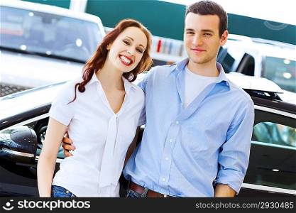 Young happy couple at car salon