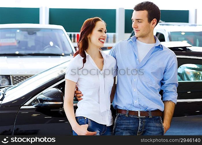 Young happy couple at car salon