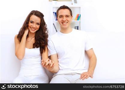 Young happy couple at home together sitting and talking