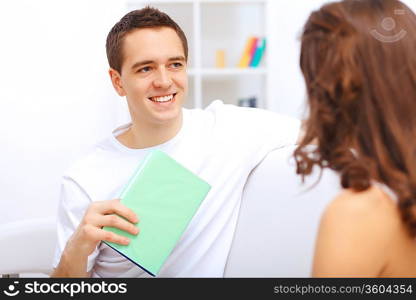 Young happy couple at hone together sitting and talking