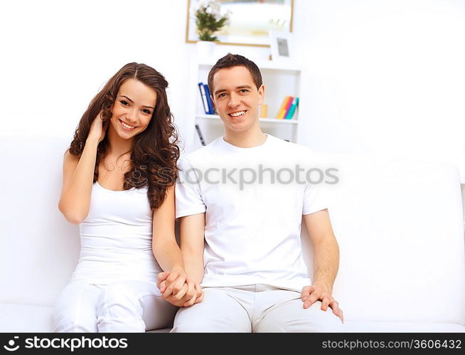 Young happy couple at hone together sitting and talking