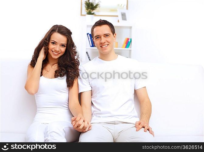 Young happy couple at hone together sitting and talking