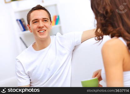 Young happy couple at hone together sitting and talking