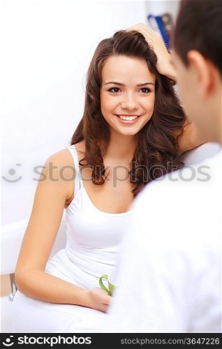 Young happy couple at hone together sitting and talking