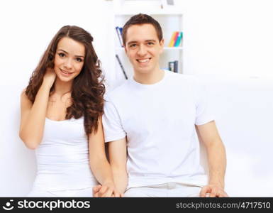 Young happy couple at hone together sitting and talking