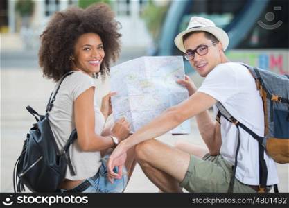 young happy couple checking a map