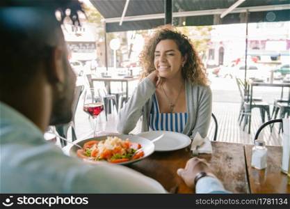 Young happy couple enjoying together while having a date at a restaurant.