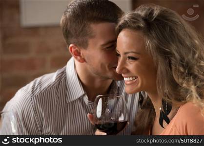 Young happy couple having romantic date at restaurant - drinking wine and eating gourmet food