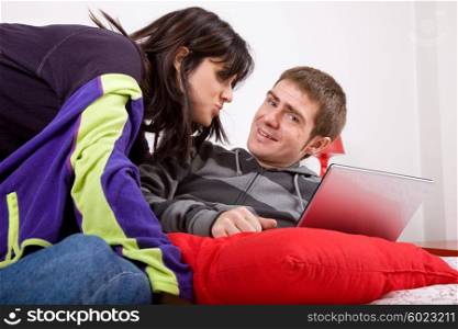 young happy couple in bed with laptop