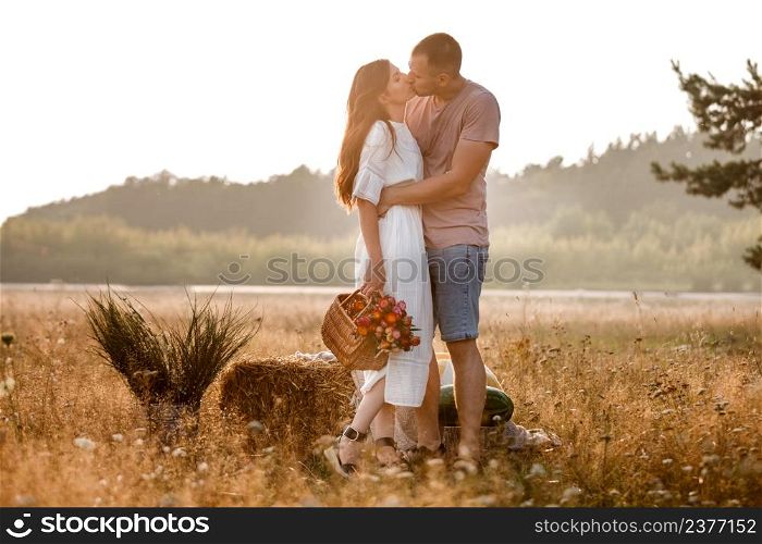 young happy couple in love kissing and hugging on nature. Man and woman hugging, sunlight in summer meadow. Happy family in the evening sun light. The concept holiday. valentine&rsquo;s day.. young happy couple in love kissing and hugging on nature. Man and woman hugging, sunlight in summer meadow. Happy family in the evening sun light. The concept holiday. valentine&rsquo;s day