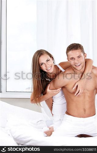 Young happy couple in the bedroom
