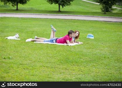 Young happy couple lying in the park on a summer day&#xA;