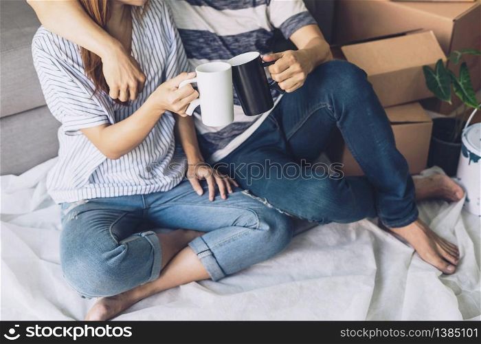 Young happy couple moving in new home, sitting and relaxing on the floor with cardboard boxes. Young happy couple moving in new home, sitting and relaxing on the floor