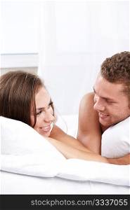 Young happy couple on the bed in the bedroom