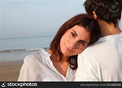 Young happy couple standing on a beach