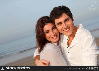 Young happy couple standing on a beach