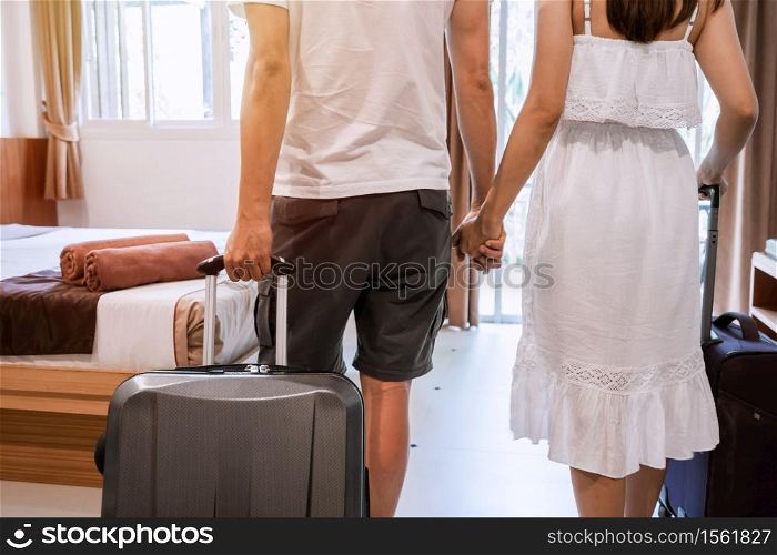 Young happy couple traveler with luggage at the hotel room on summer vacation