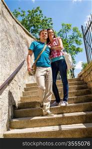 Young happy couple walking down stairs smiling in love
