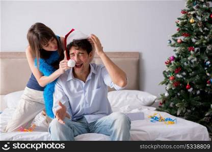 Young happy family celebrating christmas in bed